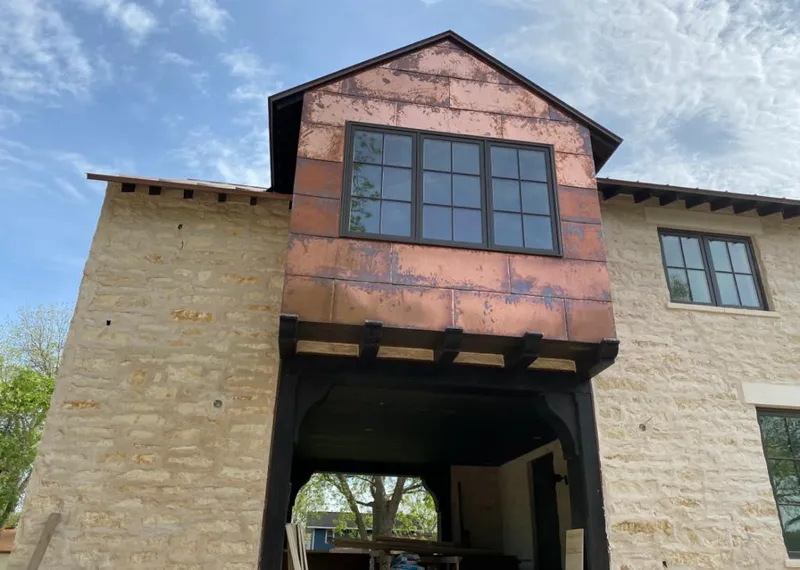 Copper metal panel facade on a stone building for Skylight Installation in Navarre